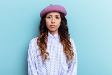 Young mexican woman isolated on blue background sad, serious face, feeling miserable and displeased.