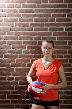 portrait of volleyball player against brick wall