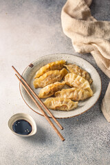 Asian dumplings with soy sauce and sesame seeds. Traditional chinese dim sum dumplings on white plate.