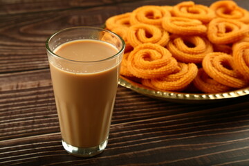 Indian milk tea, masala chai served with spicy snacks.