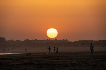 sunset on the beach of huelva with silhouettes of people