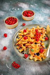 Homemade waffles with raspberries and red currants.