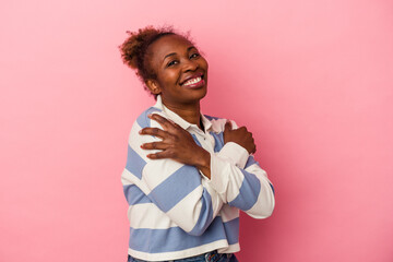 Young african american woman isolated on pink background hugs, smiling carefree and happy.