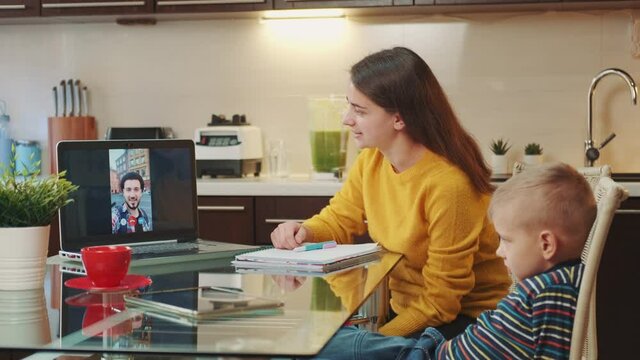 Woman with small boy having online video call with man from other country. They using computer and sitting at home.
