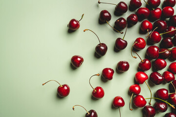 Obraz na płótnie Canvas Top view of a ripe sweet cherry on green background
