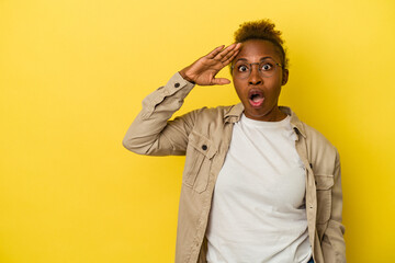 Fototapeta premium Young african american woman isolated on yellow background looking far away keeping hand on forehead.