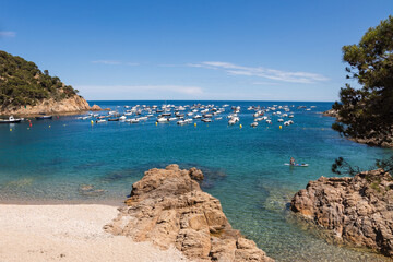 Tamariu beach in Costa Brava, azure bay with boats and yachts, Spain