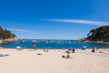 Fototapeta na wymiar Tamariu beach in Costa Brava, azure bay with boats and yachts, Spain