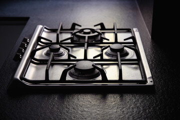 Modern steel gas stove built into a black worktop, gas bills, rise in price of gas, consumption