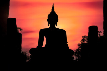 Silhouette of Buddha at outdoor temple in Sukhothai Historical Park, Thailand