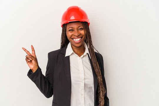 Young african american architect woman isolated on white background joyful and carefree showing a peace symbol with fingers.