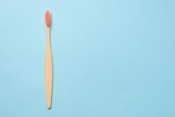 Bamboo toothbrush on a blue background.