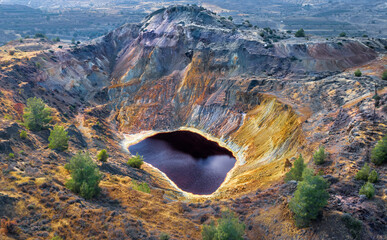 Acid red lake and colorful rocks in abandoned mine pit near Kampia, Cyprus. This area has large...
