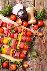 raw beef and tomatoes skewer on wooden board