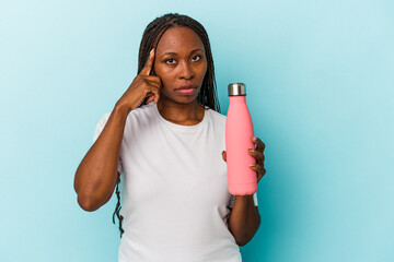 Young african american woman holding canteen isolated on blue background pointing temple with finger, thinking, focused on a task.
