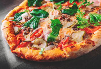 Pizza with Mozzarella cheese, Bolognese sauce, minced meat, bacon, tomato and vegetables. Italian pizza on wooden background.