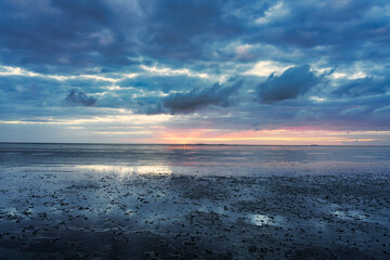 Sonnenuntergang im bewölkten Wattenmeer