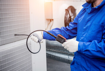 the technician uses a digital camera to check the clogging of the heat exchanger