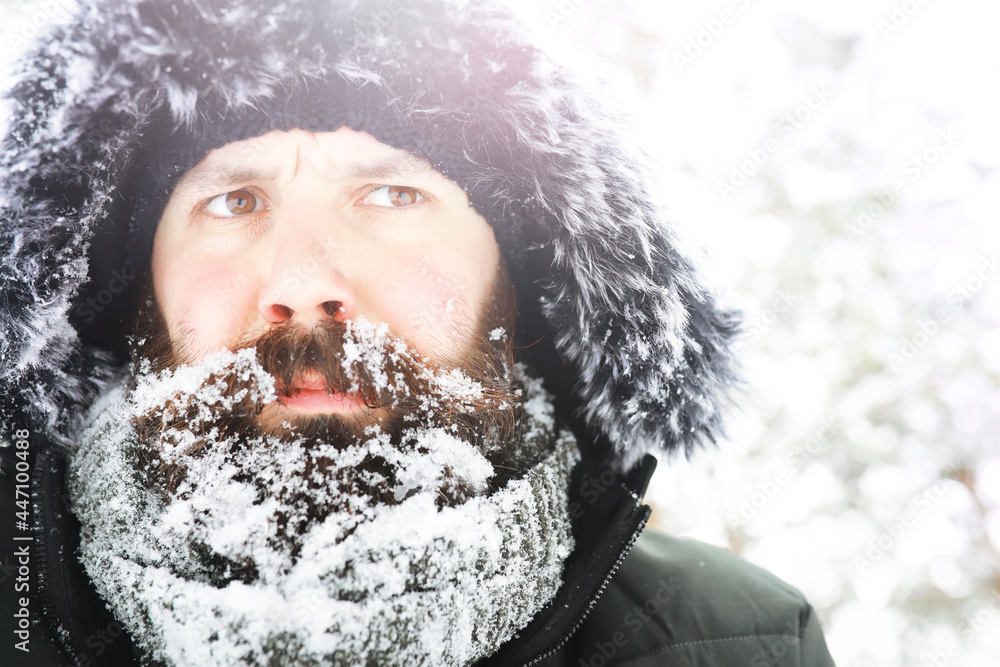 Wall mural outdoor portrait of handsome man in coat and scurf. bearded man in the winter woods.