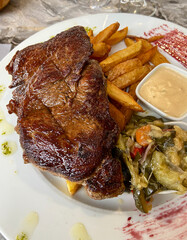 Steak frites, légumes et sauce au poivre sur une assiette 