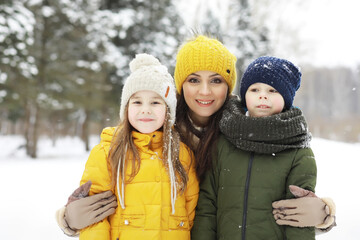 Fototapeta premium Happy family playing and laughing in winter outdoors in the snow. City park winter day.