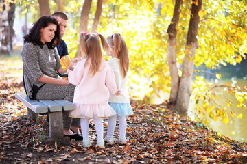 Leaf fall in the park. Children for a walk in the autumn park. Family. Fall. Happiness.