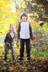 Fototapeta premium Young family on a walk in the autumn park on a sunny day. Happiness to be together.