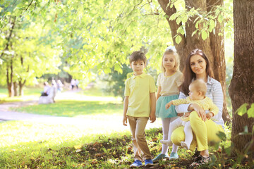 Obraz premium Family with children for a walk in the summer park. Сoming autumn&nbsp;in the park. Family. Fall. Happiness.
