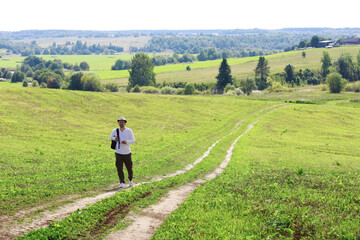 A man makes a tourist trip to the village. Flooded fields, meadows, a country road, a sunny day and a walk in the fresh air.