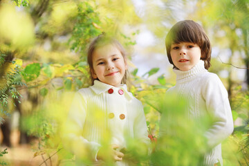 Children for a walk in the autumn park. Leaf fall in the park. Family. Fall. Happiness.