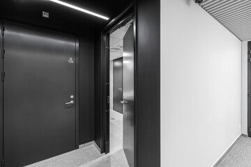 Interior of a modern public restroom with grey clay tiles and anthracite doors