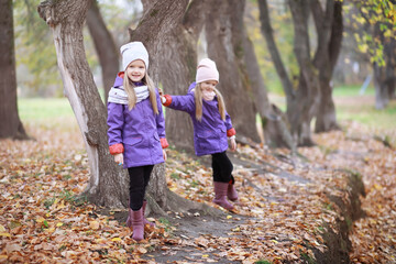 Young family on a walk in the autumn park on a sunny day. Happiness to be together.