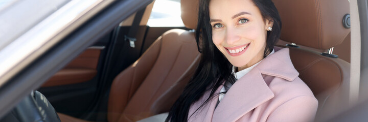 Smiling woman sit on modern brown car portrait