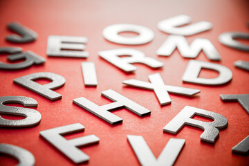 Mixed letters pile close up view photo. Red background