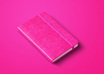 Pink closed notebook isolated on color background