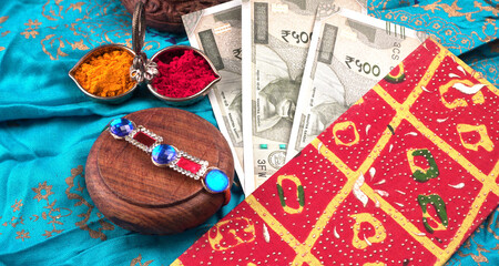 Indian festival: Raksha Bandhan background with an elegant Rakhi, Rice Grains and Kumkum. A traditional Indian wrist band which is a symbol of love between Brothers and Sisters.
