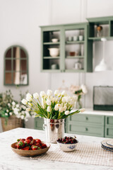 White tulips in metal bucket on countertop