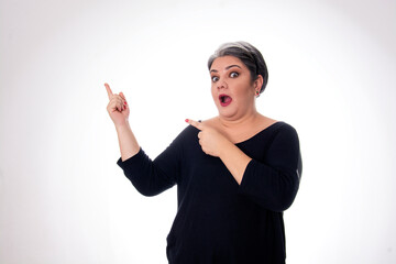 people diversity young lady with white hair pointing fingers to the side with open mouth wearing black on white background