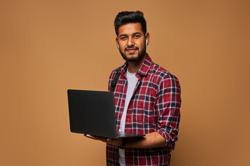 Happy hindu manager in casual close with laptop on pastel background