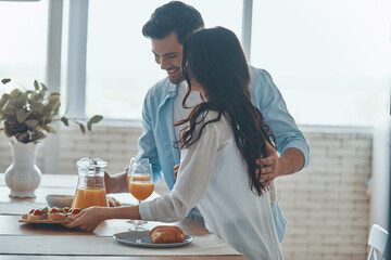 Beautiful young couple preparing breakfast together while spending time in the domestic kitchen