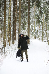 Naklejka premium Bearded man in the winter woods. Attractive happy young man with beard walk in the park.