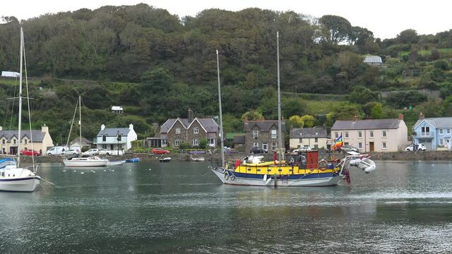 Panning shot of Fishguard bay with boats and yachts and lower town in Pembrokeshire, Wales.