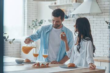Beautiful young couple preparing breakfast together while spending time in the domestic kitchen