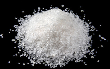 A slide of white sea salt is isolated on a black background.
