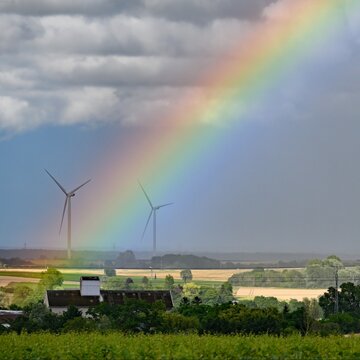 A Rainbow Seems To Shoot Out Between Two Wind Turbines