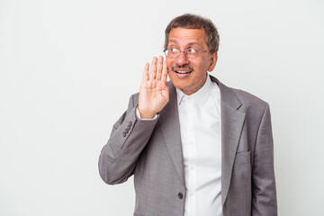 Middle aged indian business man isolated on white background is saying a secret hot braking news and looking aside