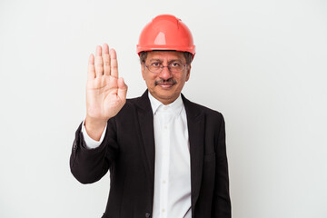 Middle aged indian architect man isolated on white background standing with outstretched hand showing stop sign, preventing you.