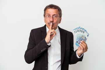 Middle aged indian business man holding bills isolated on white background keeping a secret or asking for silence.