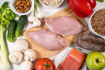 Protein Menu: Meat, Fresh Vegetables, Fruits, and Nuts. Healthy food on white stone background.