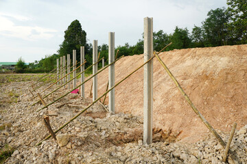 Prestressed concrete fence posts are placed in rows to form a fence wall.
